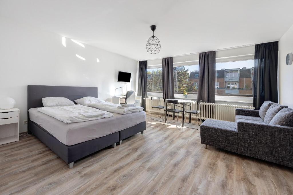 a bedroom with a bed and a couch and a desk at Hansa Nest in Hamburg
