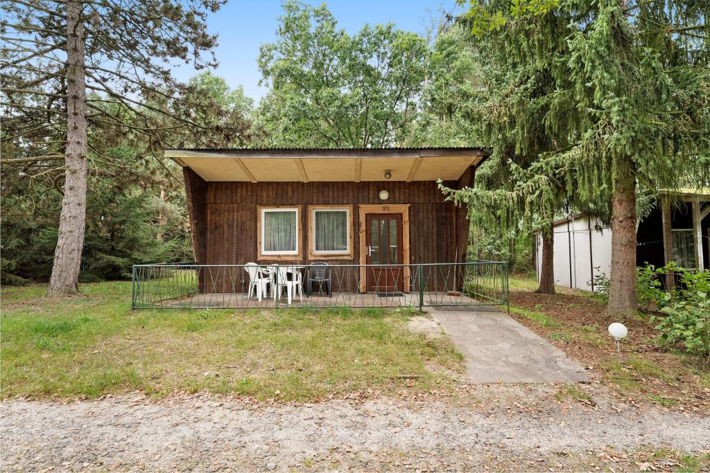 a cabin in the woods with a porch and chairs at Bungalow 26 - Kimbucht in Reichendorf