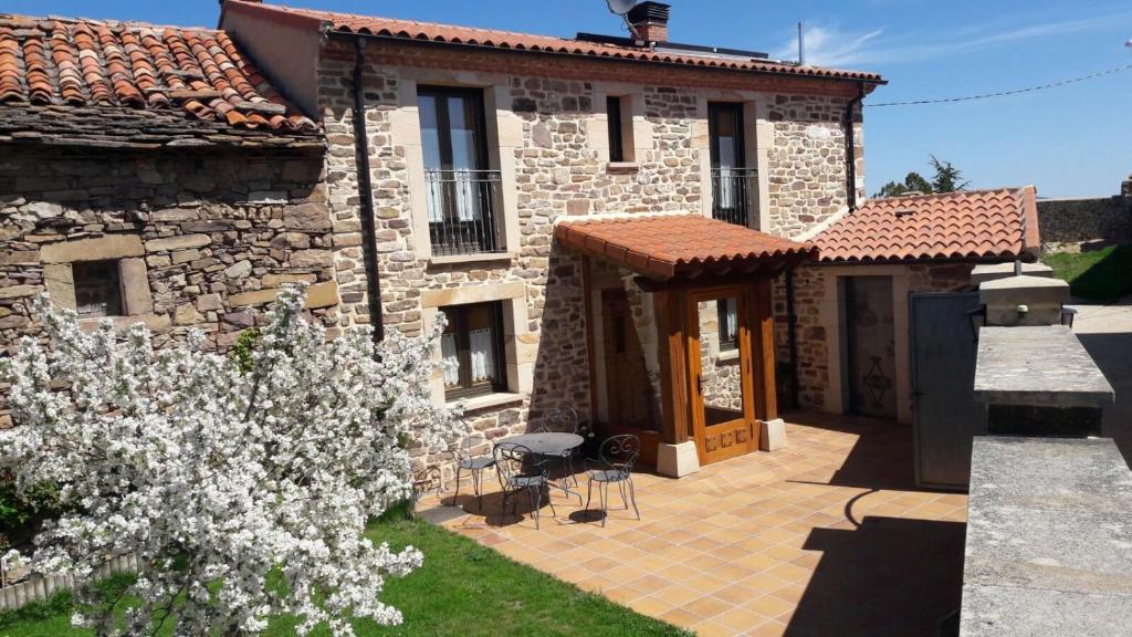 a stone house with a garden in front of it at Montes De Alhama in Villarraso