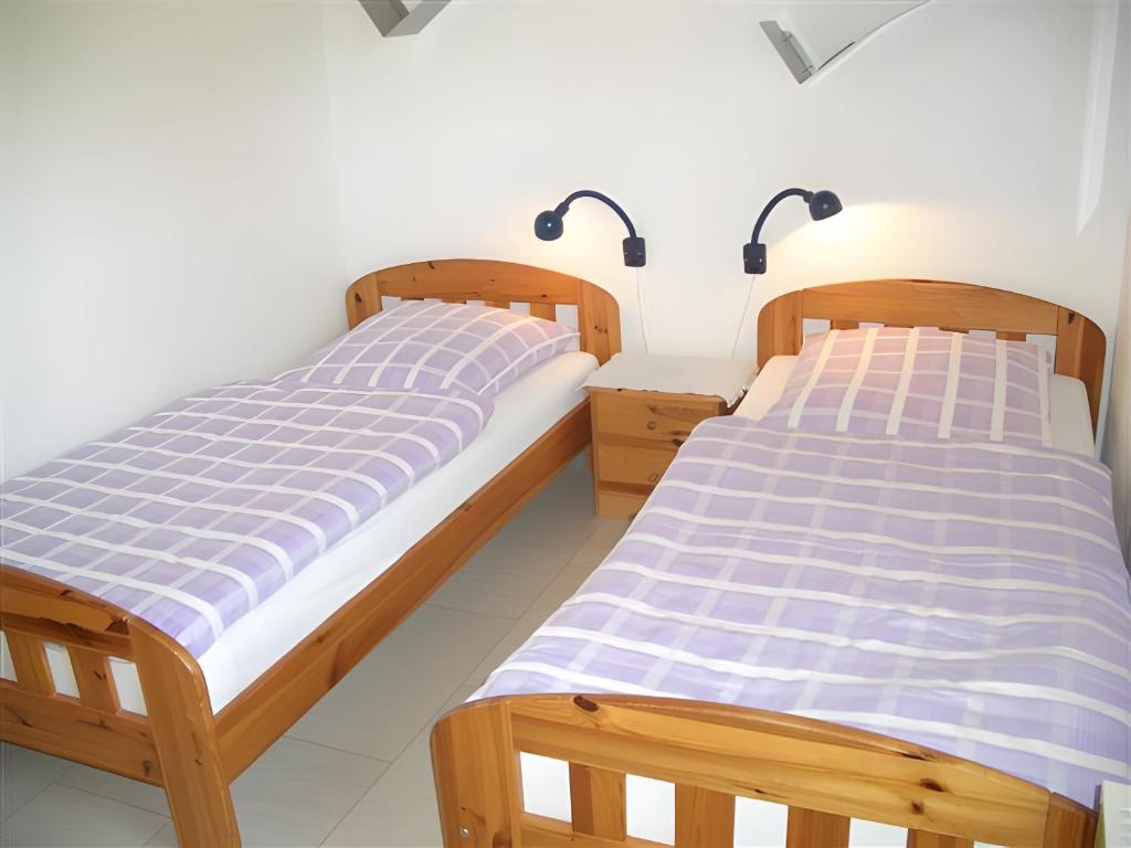 two beds sitting next to each other in a bedroom at Ferienhaus Uslar Gmbh Uslar in Uslar