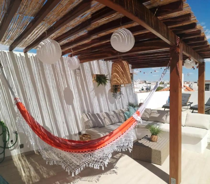 a hammock on a patio with a view of the ocean at Bougainvillea House in Tavira