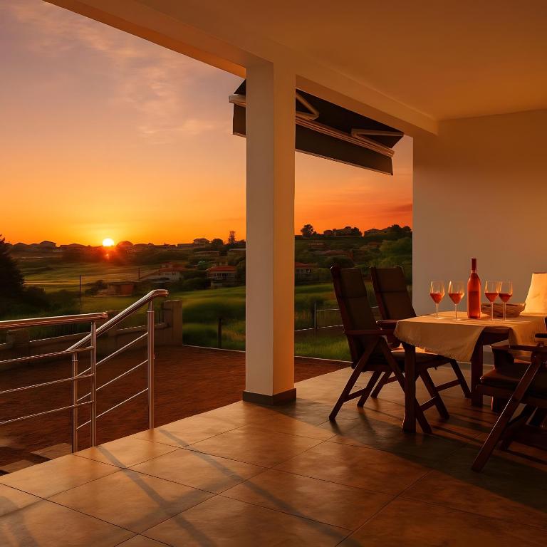 a patio with a table and chairs and a sunset at Sunset Sea View Cottage in Nea Potidaea