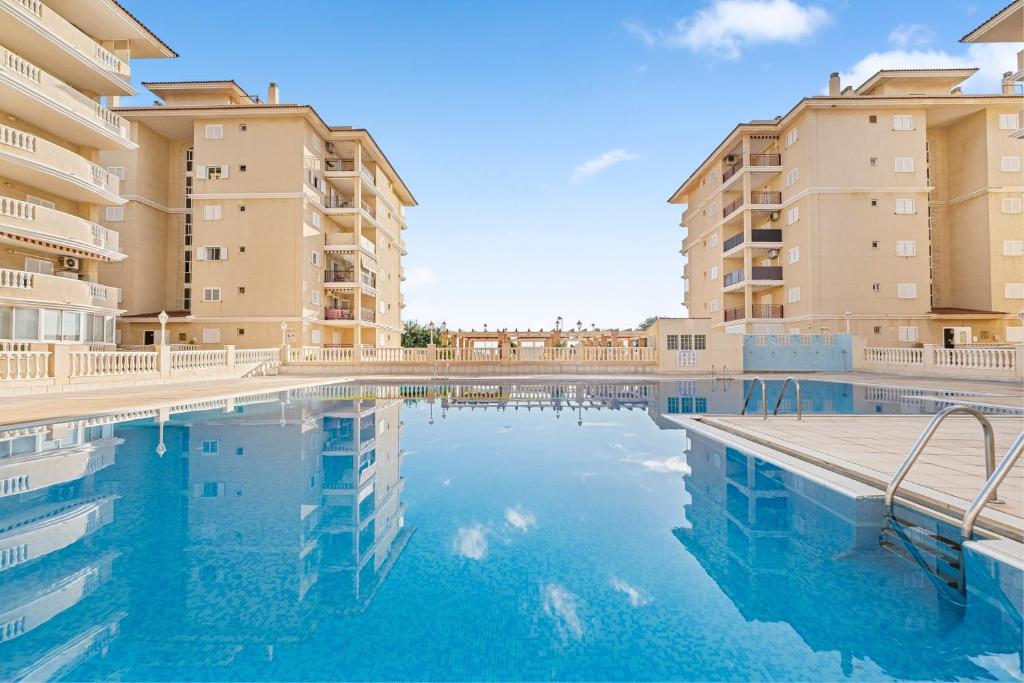 a swimming pool with two tall apartment buildings at Viñamar 7 in La Mata