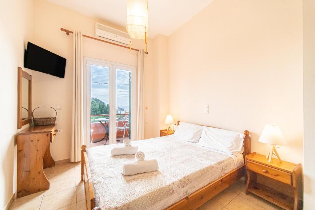 a bedroom with a bed and a large window at Arianna Studio 12 in Paleokastritsa
