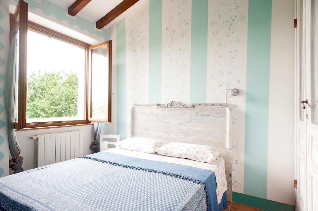 a bedroom with a bed with blue and white stripes at Mare Colline Città d'Arte in Rosignano Marittimo