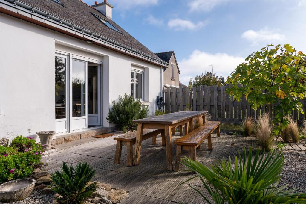 a patio with a wooden table and benches at Ty Eole Maison Tout Confort 10p in Quiberon