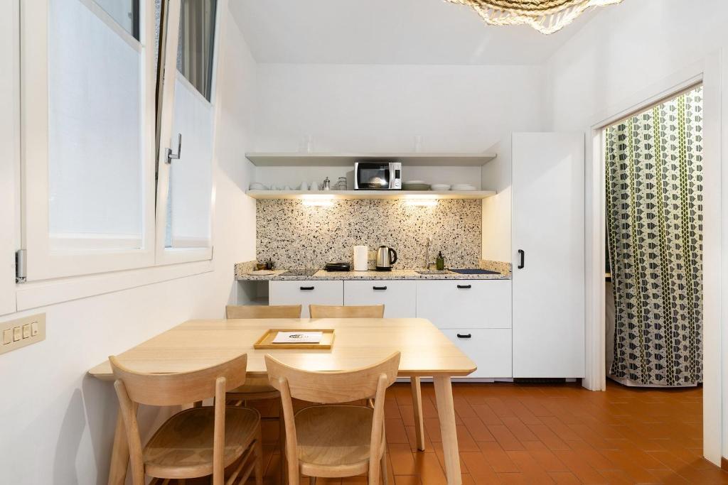 a kitchen with a wooden table and chairs at U Canetta 2 in Pietra Ligure