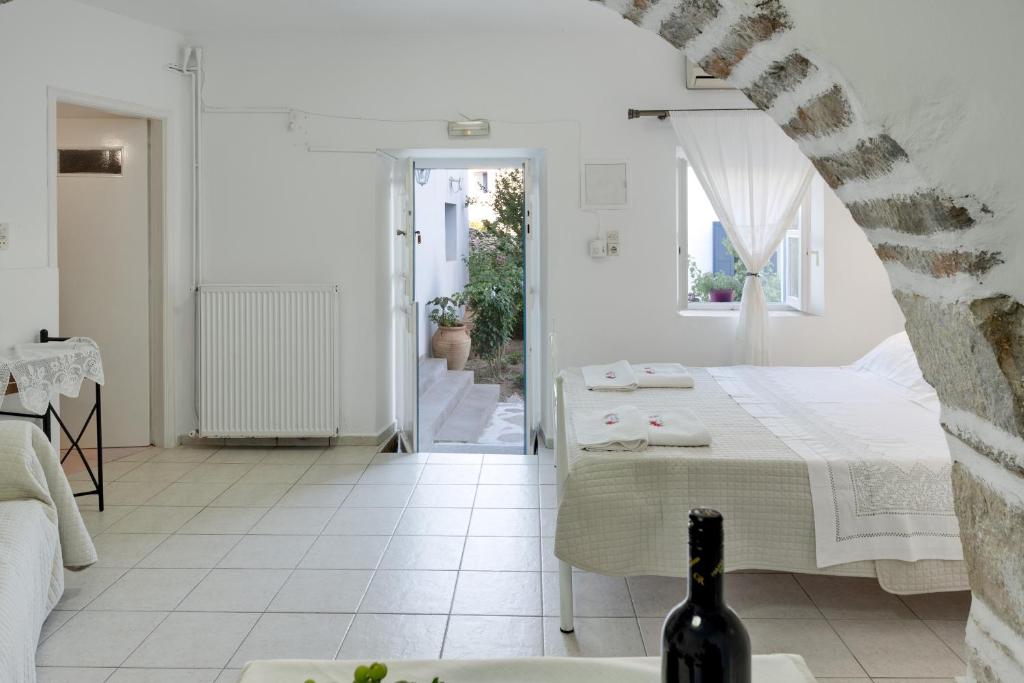a white room with a bed and a table at Politimis Studio N7 in Amorgos