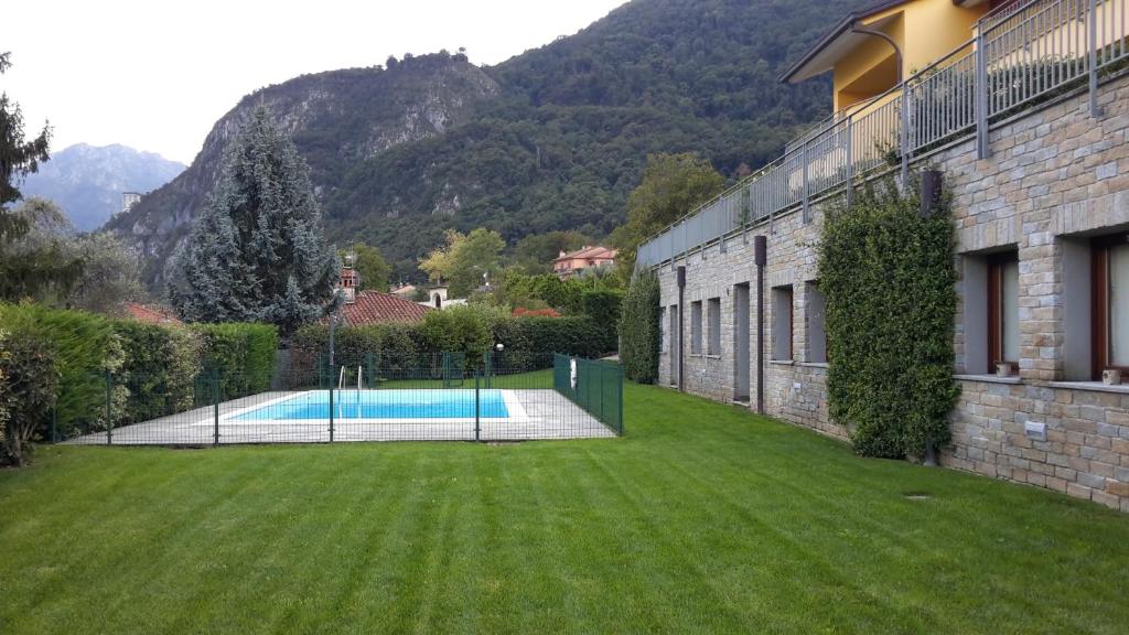 a swimming pool in a yard next to a building at New Eleven Apartment on Como Lake in Oliveto Lario