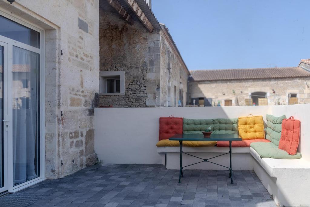 a bench with colorful pillows sitting on a balcony at Le Luna in Vindelle