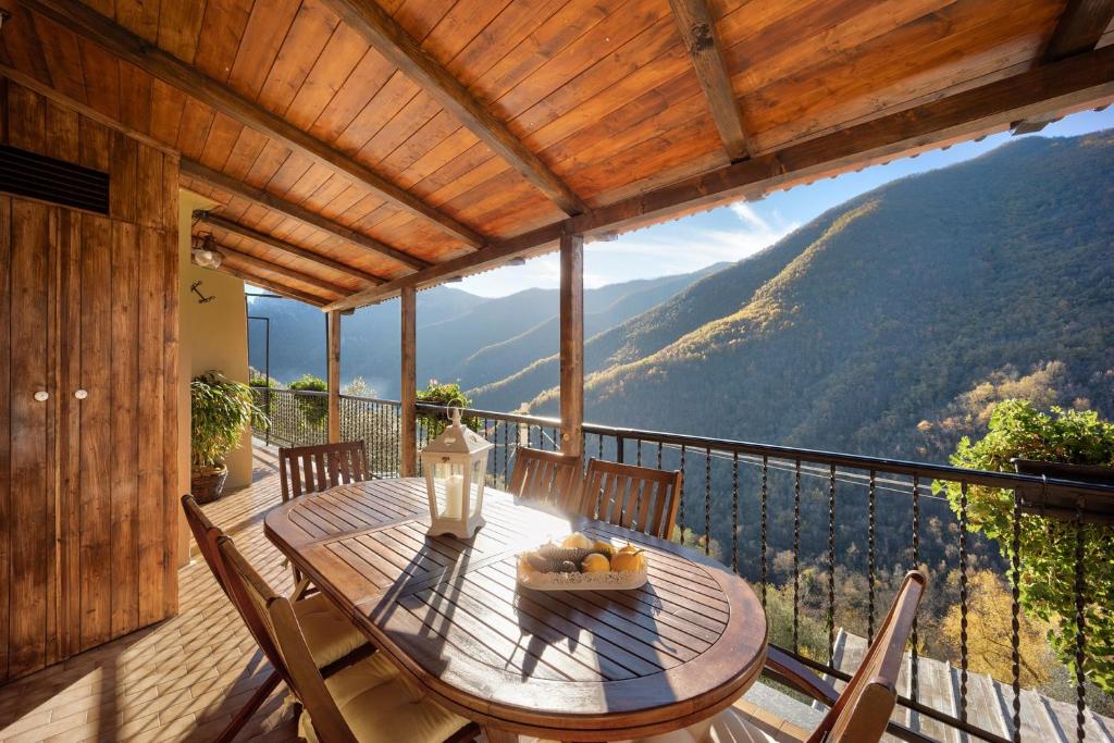a wooden table with a bowl of fruit on a balcony at Agriturismo U'Spigu Nonna Annetta in Nasino