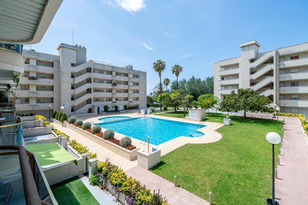 an apartment with a swimming pool in a yard with buildings at Cambrils park in Cambrils