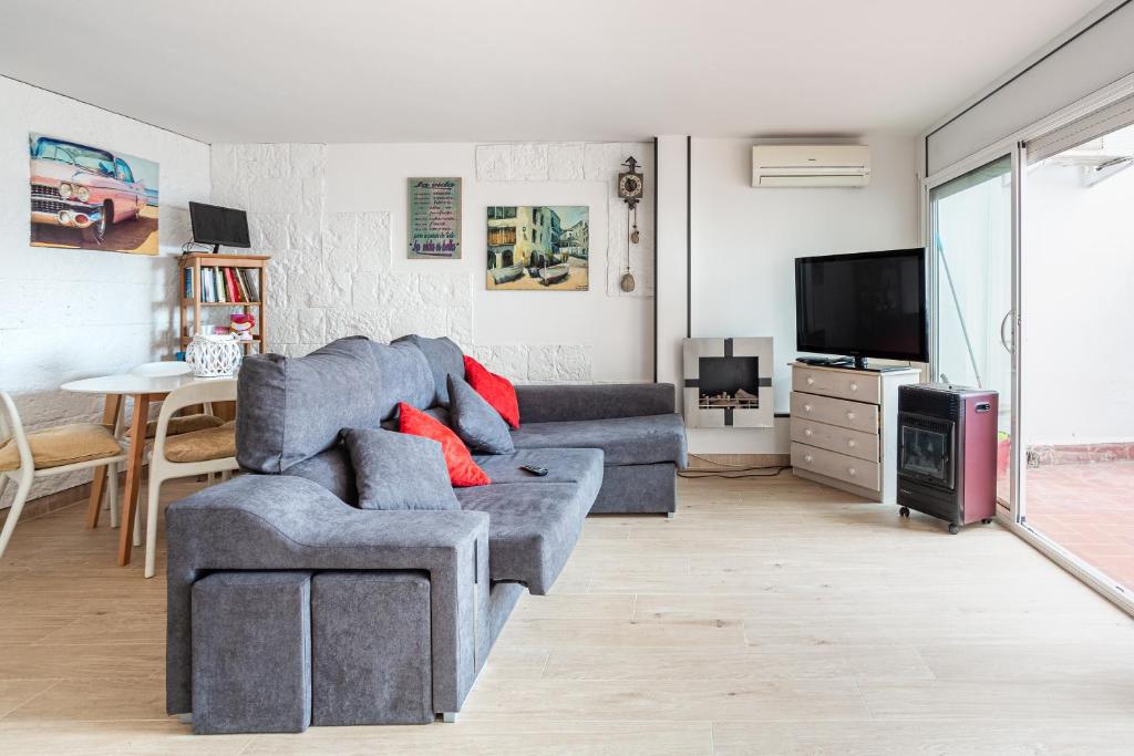 a living room with a couch and a tv at Ca La Nyca in Tossa de Mar