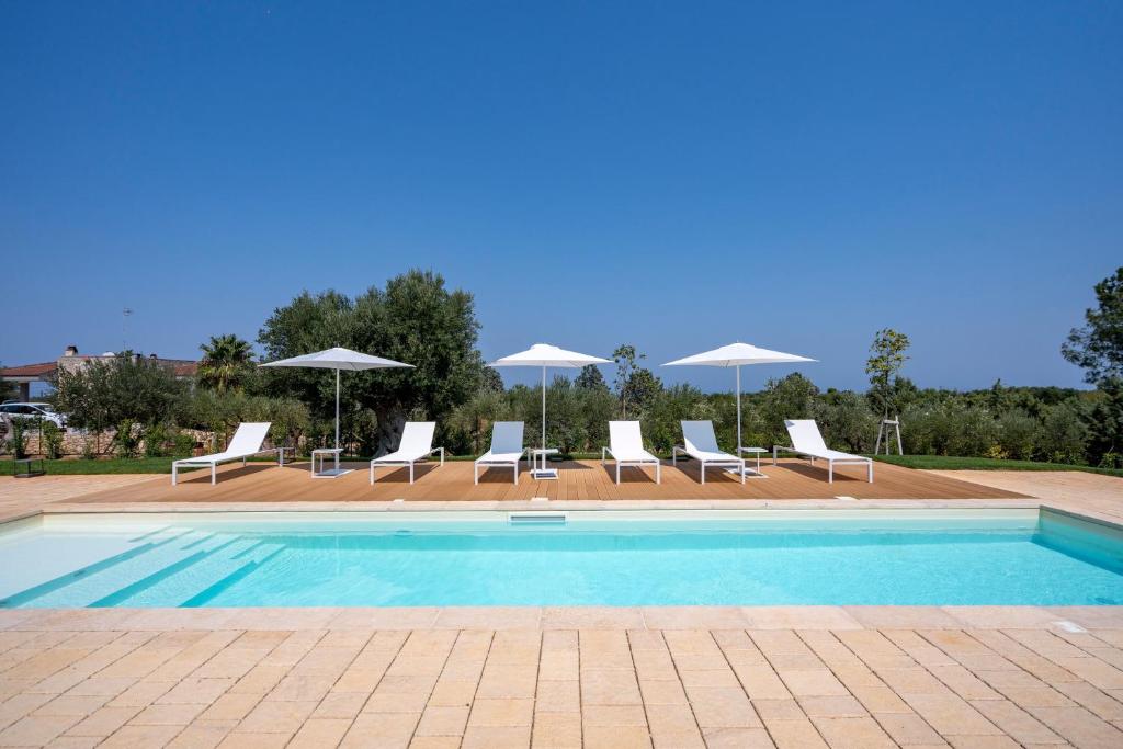 a swimming pool with lounge chairs and umbrellas at Villa Capobianco in Polignano a Mare