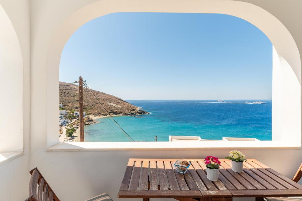 a table with a view of the ocean from a window at Ammos Tinos in Istérnia