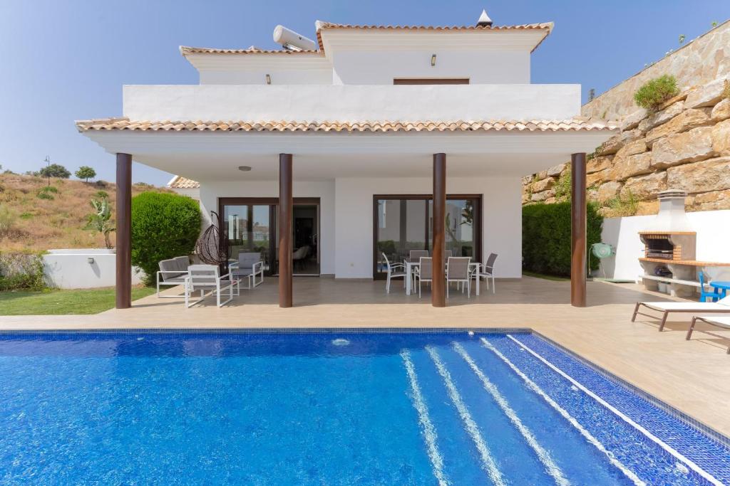 a villa with a swimming pool and a house at Chalet En La Cala De Mijas Costa in Mijas Costa