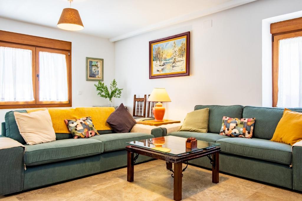 a living room with two couches and a coffee table at Quercus in Navaluenga