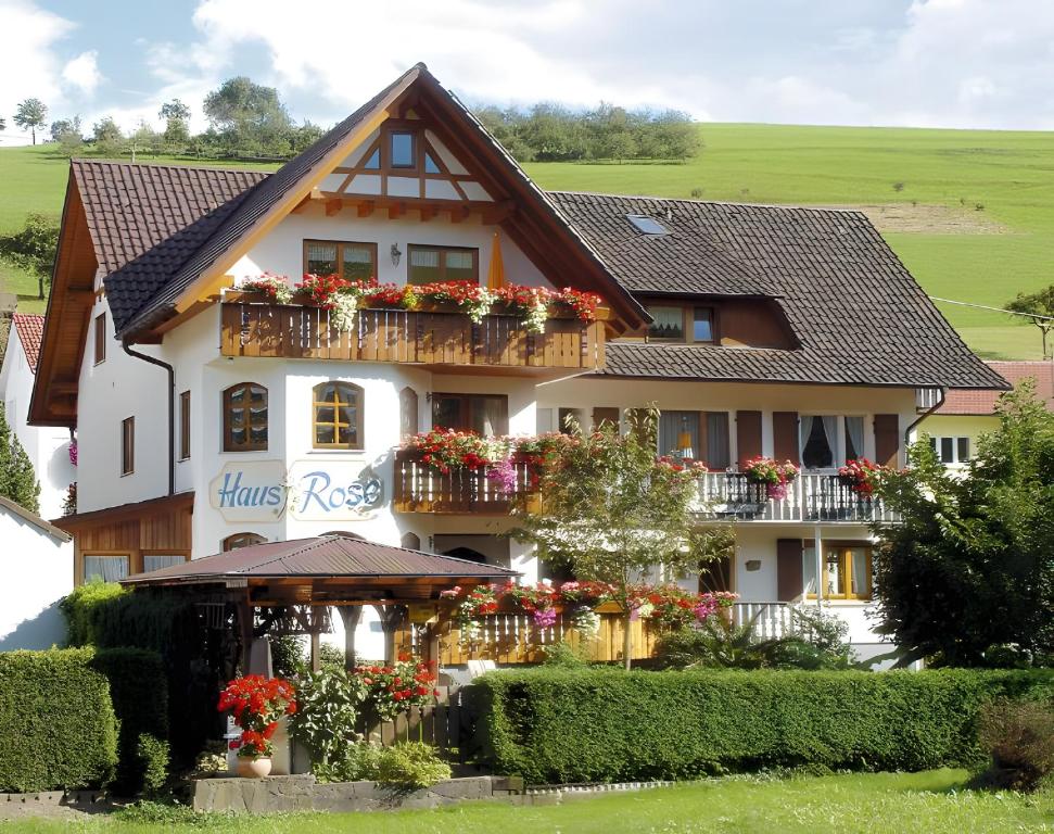 a house with flowers on the balconies of it at Pension Haus Rose in Oberharmersbach