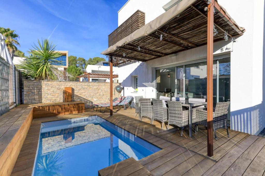a patio with a pool and a table and chairs at Chambre Villa illiade in Jacou