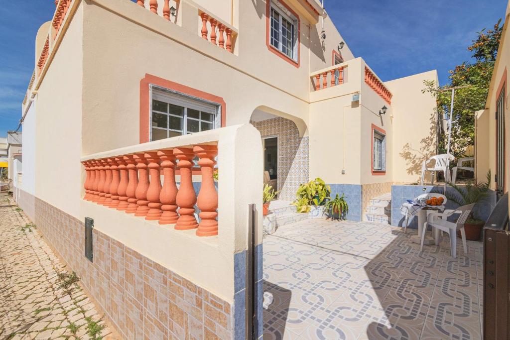 a house with a balcony and a patio at Casa Do Sol - Estombar Algarve in Estômbar