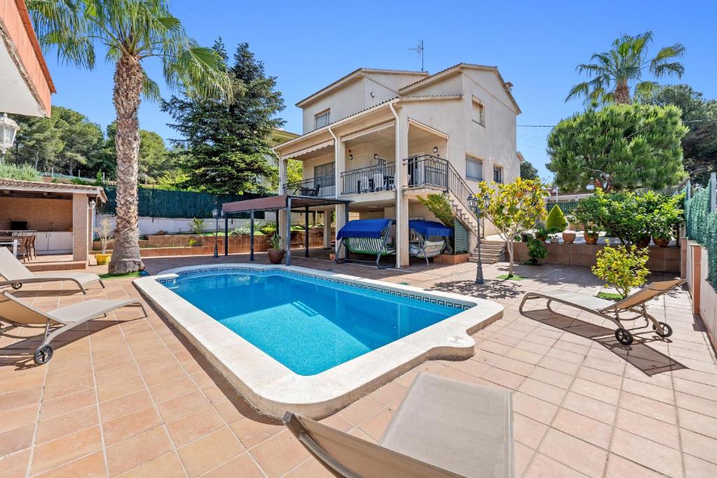 a swimming pool in the backyard of a house at Casa Anglada in Calafell