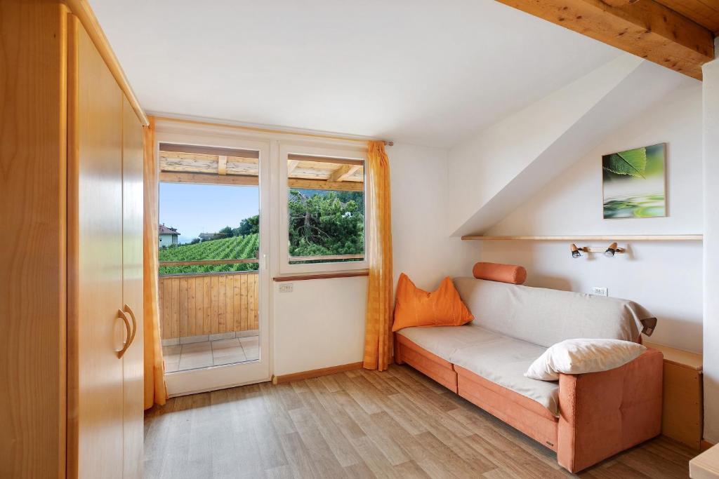 a living room with a couch and a large window at Harmony Apt 1 in Appiano sulla Strada del Vino