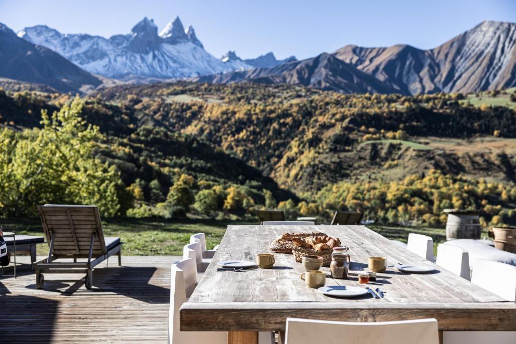 a table on a deck with a view of mountains at Chalet D'albiez in Albiez-Montrond
