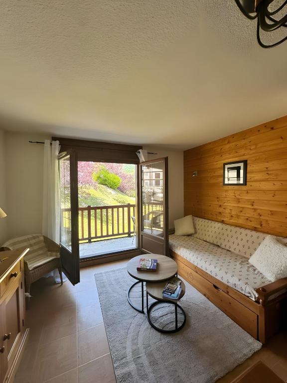 a living room with a couch and a table at Les evettes 4-6 couchages in Flumet