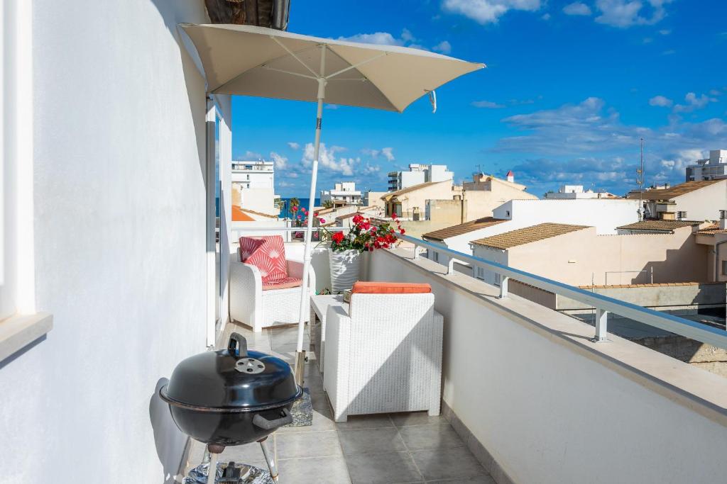 a grill on a balcony with a view of the city at Can Picafort Sea Breeze in Can Picafort