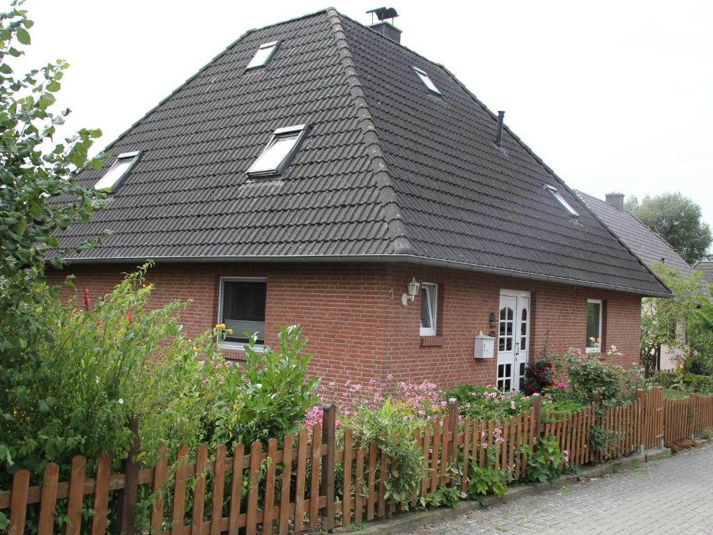 a red brick house with a black roof at Ferienwohnung an der Müritz in Klink