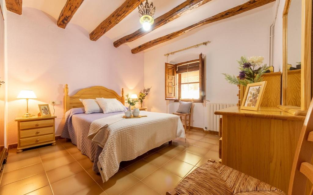 a bedroom with a bed and a table and a window at Ca La Rosalia in El Pla de Manlleu