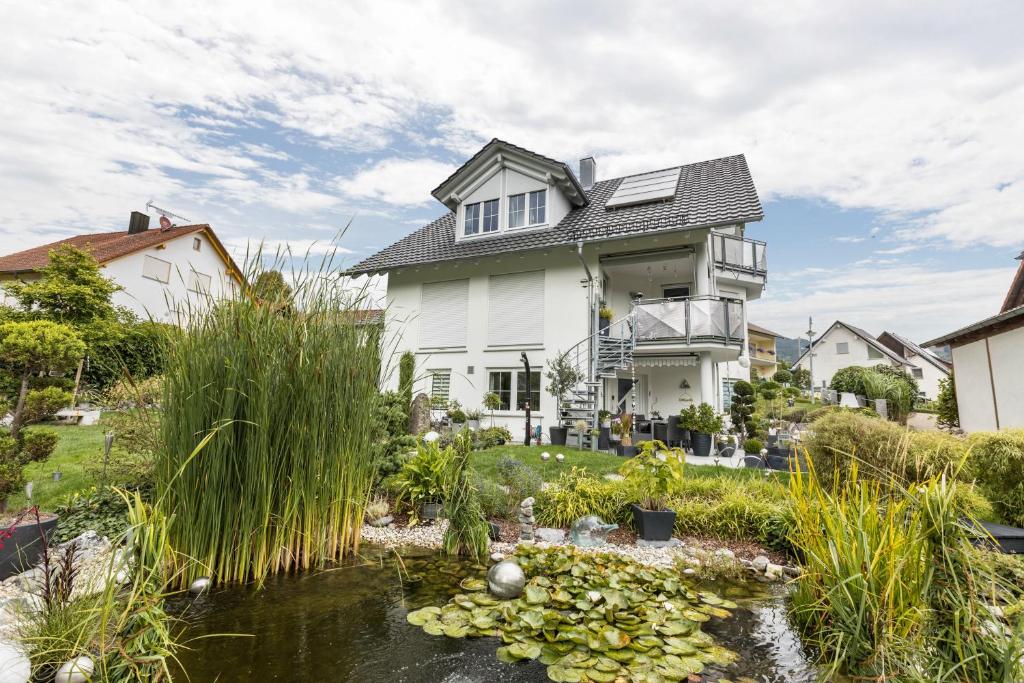 a house with a pond in the front yard at Ferienwohnung Griesbaum in Tengen
