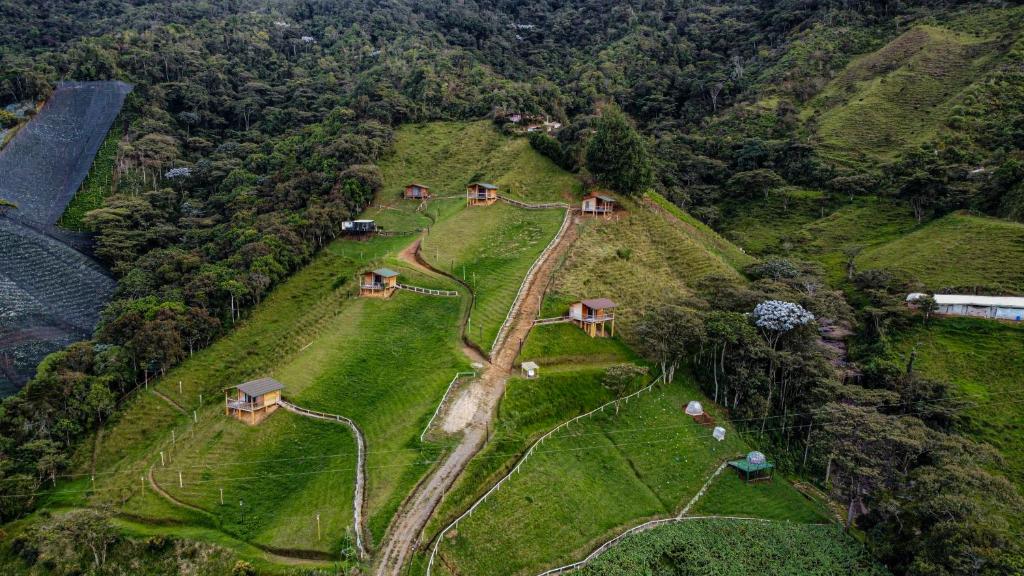an aerial view of a farm with houses on a hill at Ecoparque Hotel El Cielo Cabañas in Carmen de Viboral