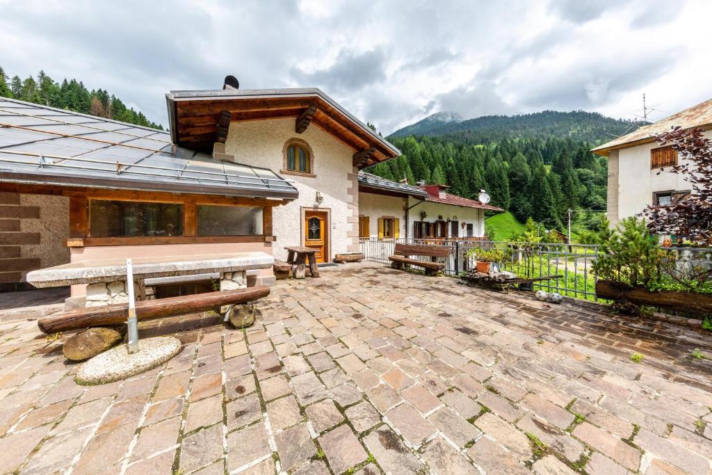 a house with a stone patio in front of a building at Casa Montagna in Cadore in San Pietro di Cadore