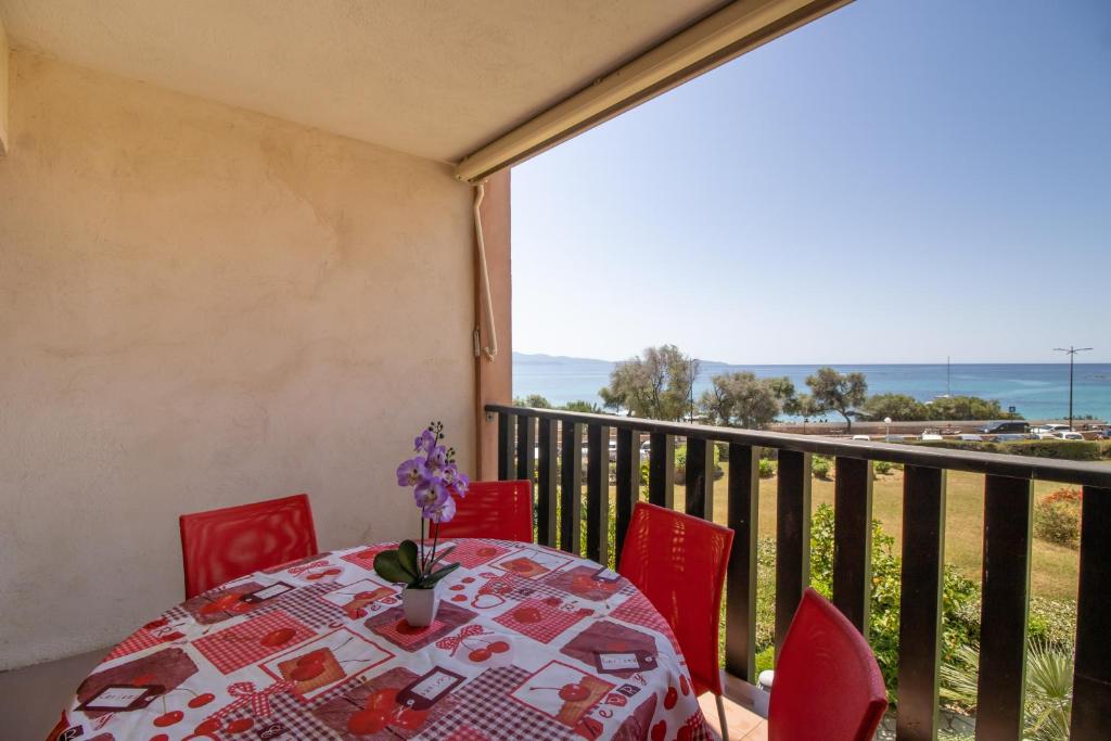 a table and chairs on a balcony with a view of the ocean at Résidence Aria Marina Plage in Ajaccio