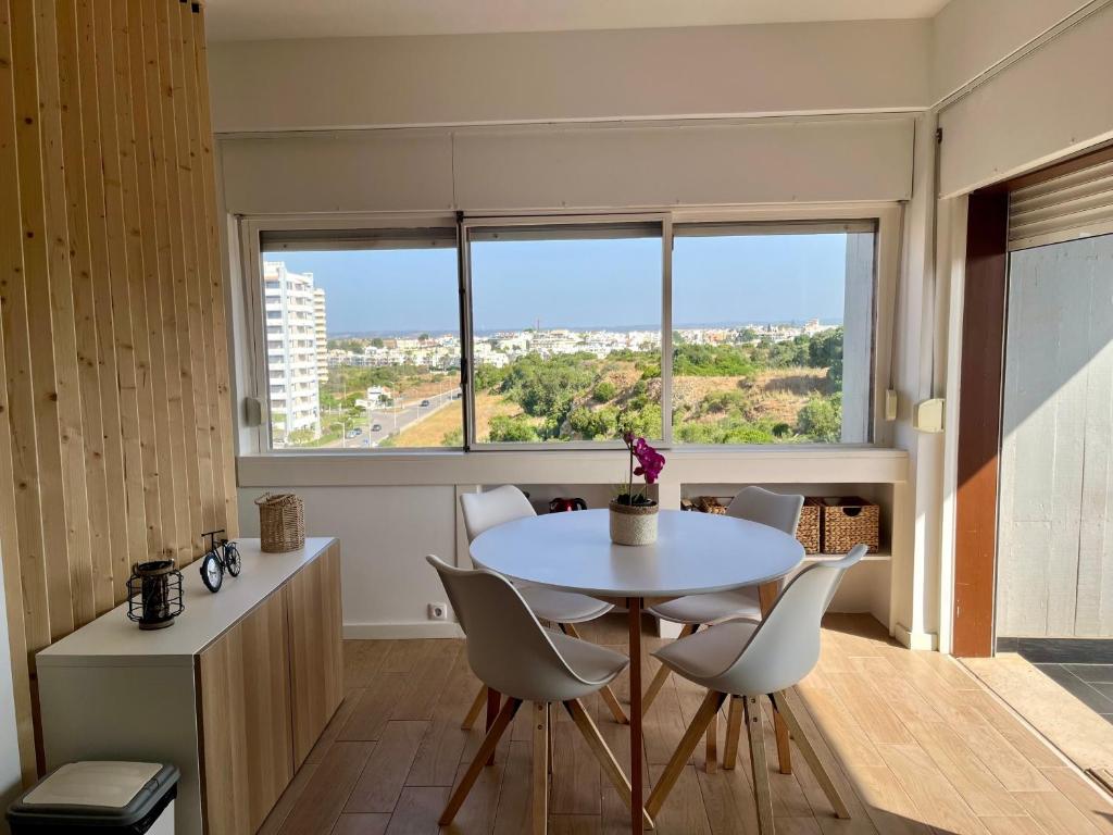 a dining room with a table and chairs and a window at Sunset Studio in Alvor