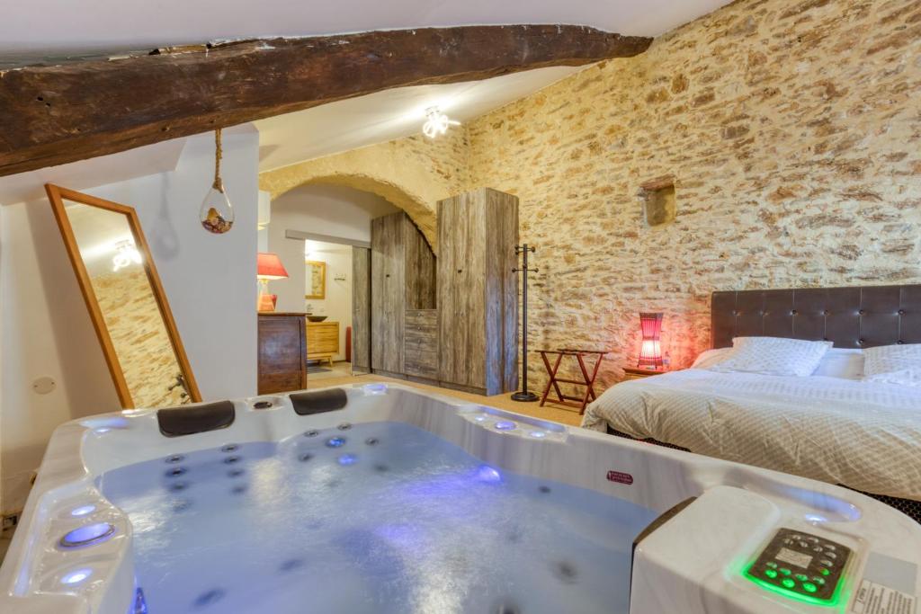 a bath tub in a bedroom with a bed at Forgerole in Faugères