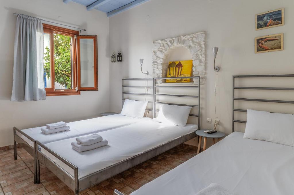 two beds in a room with white walls at En Tino 2 in Tinos