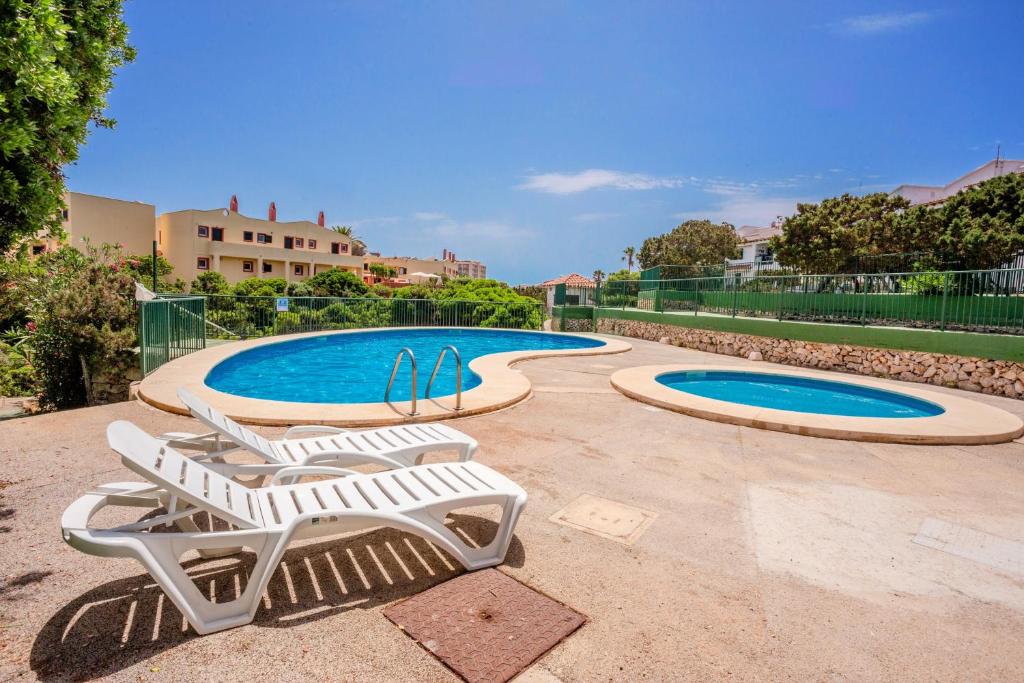 a pair of lounge chairs and a swimming pool at Biniforcat 21 in Cala en Forcat