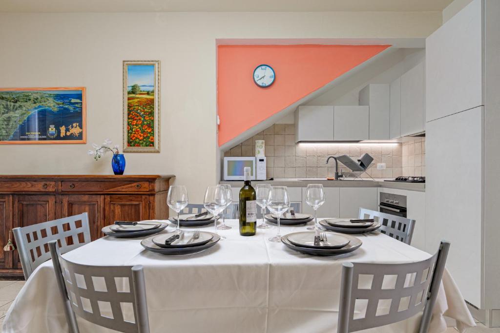 a dining room table with a white table cloth and wine glasses at Trilo La Rosa in Monte Petrosu