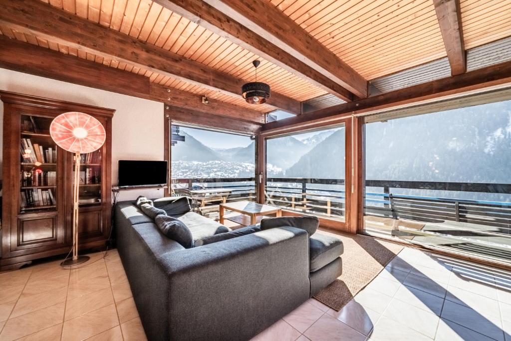 a living room with a couch and a large window at Chalet Châtel - calme et spacieux in Châtel