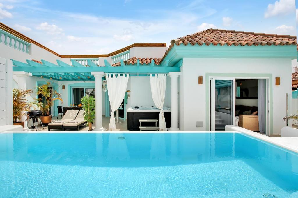 a villa with a swimming pool and a house at Orange Light with private pool in Corralejo