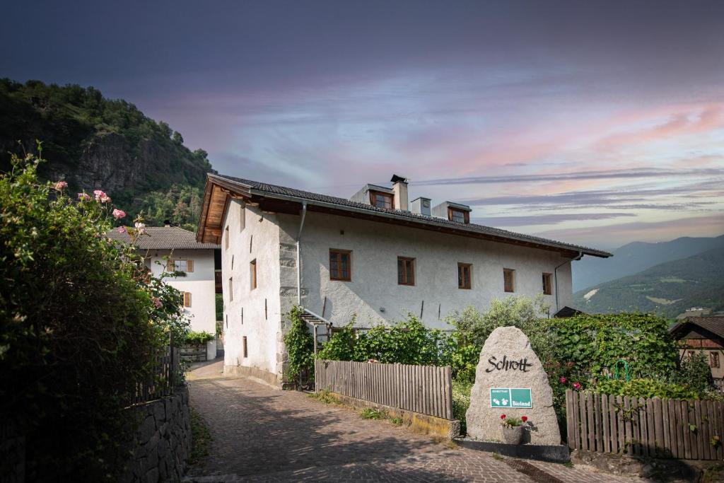 a white house on a hill with a fence at Schrotthof in Feldthurns