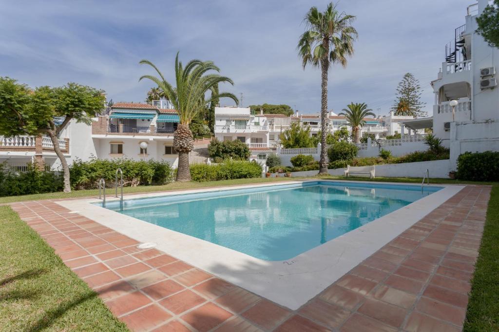 a swimming pool in the yard of a building at Mi Casa in Caleta De Velez