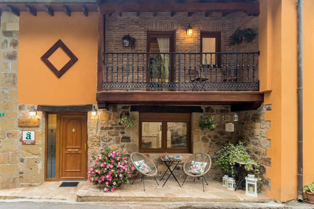 a building with a balcony with chairs and flowers at Casa Lindelagua in Pámanes