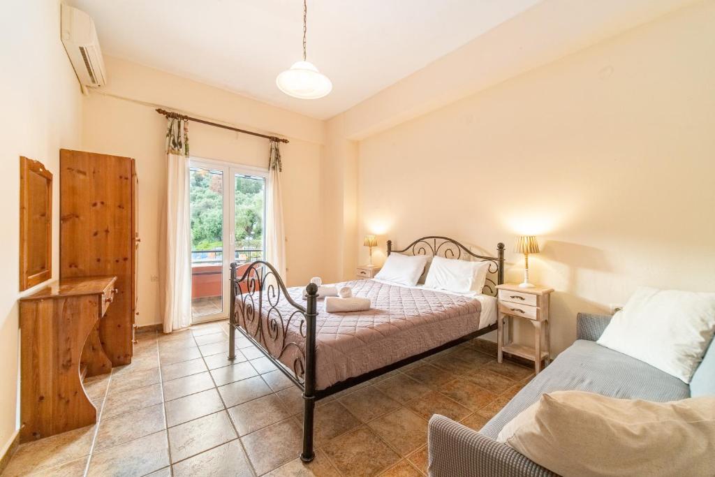 a bedroom with two beds and a window at Arianna Studio 15 in Paleokastritsa