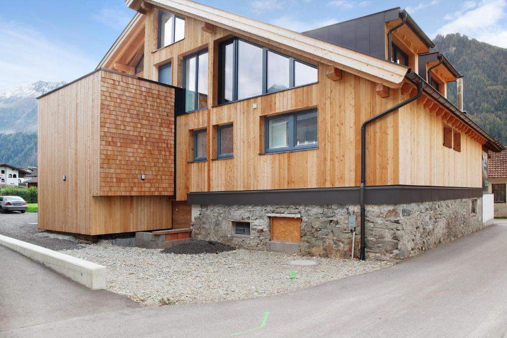 a wooden house with a stone wall at Apartement Bens Auszeit Top 6 in Umhausen