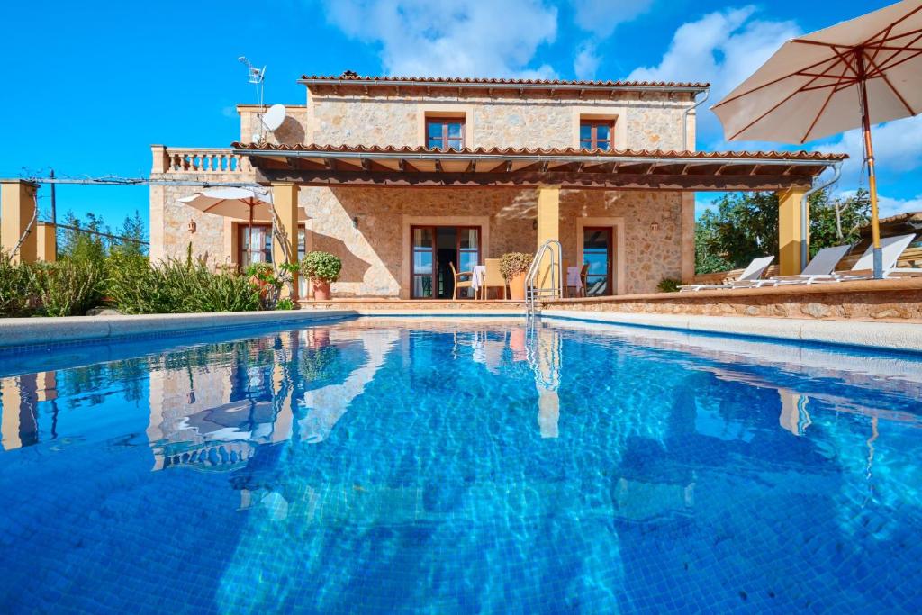 a villa with a swimming pool in front of a house at Casa Tolo in Son Servera