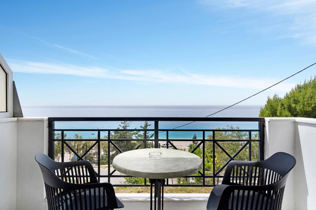 a table and chairs on a balcony with a view of the ocean at Sunset Premium Studio D in Lefkada