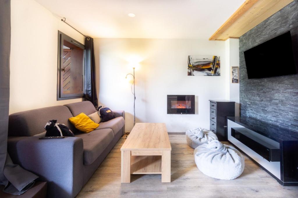 a living room with a couch and a tv at Appartement Albiez in Albiez-Montrond